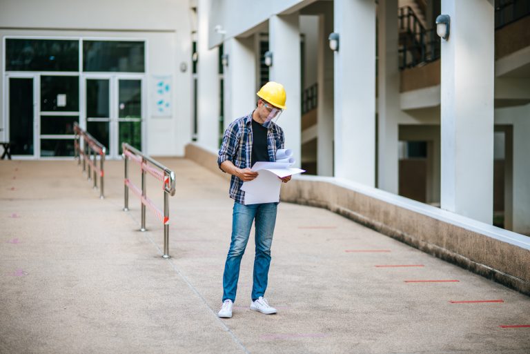 Architects hold the building plan and check the work.