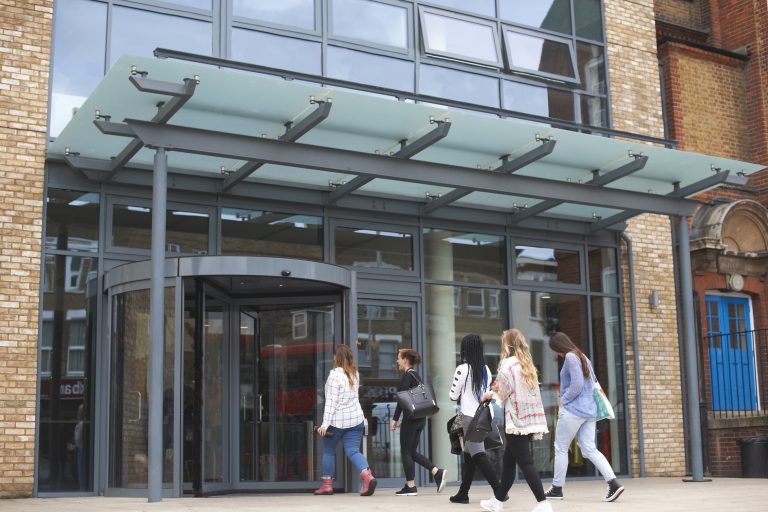 Group of students entering building, rear view